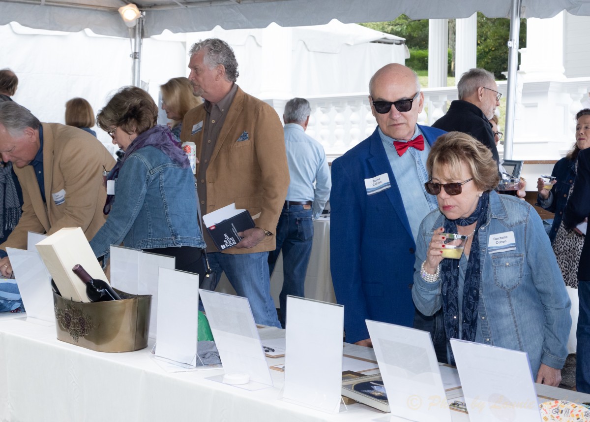 Guests review items in the silent auction tent.