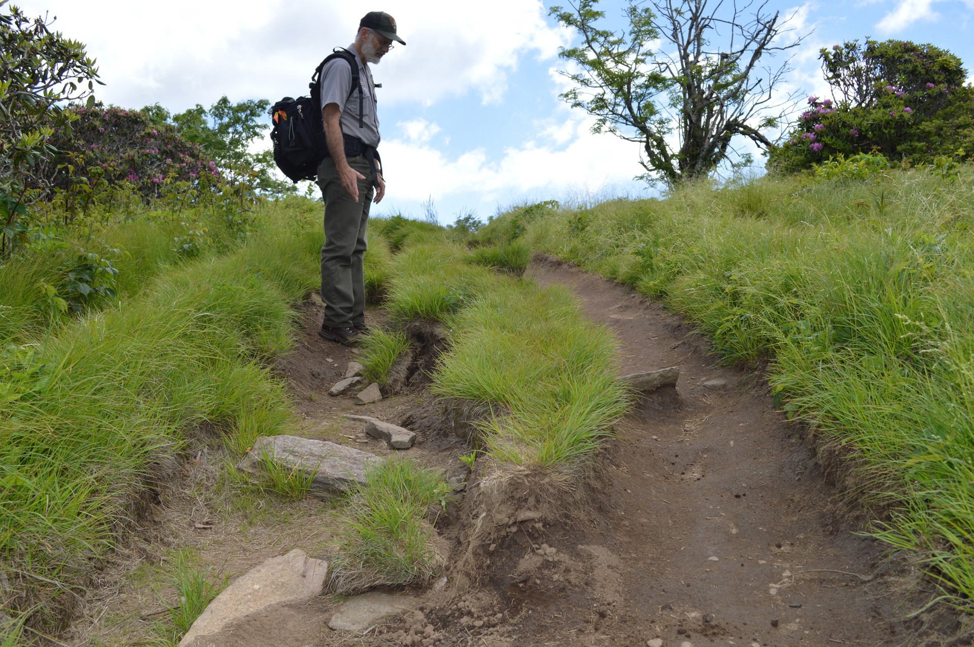 Blue Ridge Parkway botanist Chris Ulrey surveys the damaged trail at Craggy Bald. 