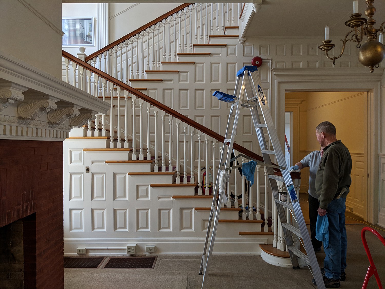 NPS staff clean the woodwork on the stairway at Flat Top Manor at Moses H. Cone Memorial Park.
